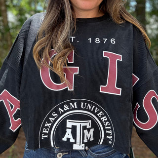Person wearing a black Texas A&M University sweater with red and white text-ava wray boutique