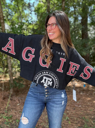 Woman wearing a black 'AGGIES' Texas A&M University sweatshirt with arms outstretched outdoors-ava wray boutique