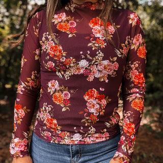 Person wearing a long-sleeve top with a floral pattern outdoors-ava wray boutique