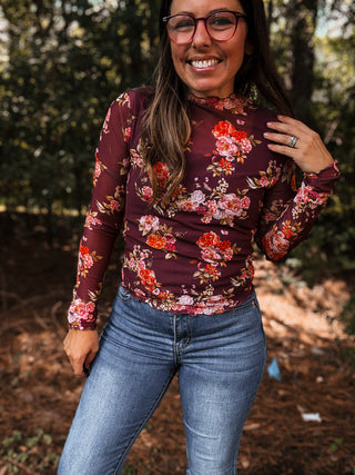 Woman wearing a floral long-sleeve top and jeans outdoors-ava wray boutique