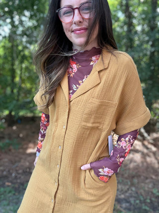 Woman wearing a mustard yellow dress with floral sleeves outdoors- ava wray boutique