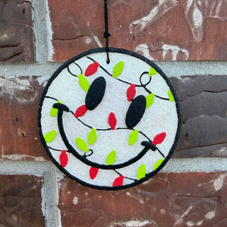 Smiley face Christmas car freshie wrapped in red and green holiday lights from Ava Wray Boutique.