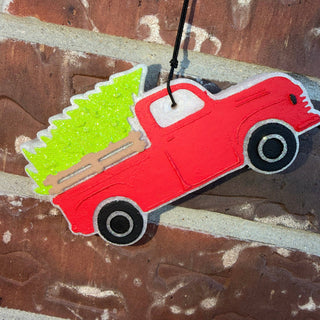 Vintage red truck car freshie carrying a glittery green Christmas tree holiday air freshener.