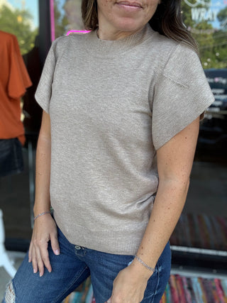 Woman wearing a beige sweater and blue jeans in an outdoor setting-ava wray boutique