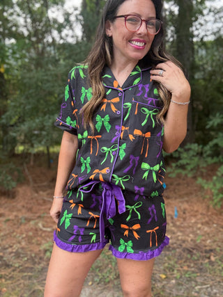 Woman wearing a colorful bow-patterned outfit outdoors=ava wray boutique