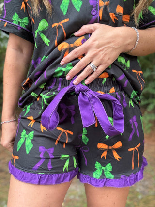 Person wearing a black outfit with colorful bows and purple accents-ava wray boutique