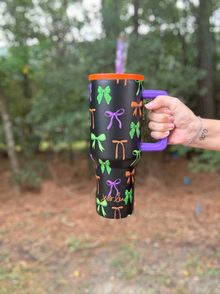 Person holding a black mug with colorful designs outdoors-ava wray boutique