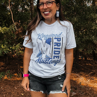 Woman wearing a 'Kingwood Pride Mustang' t-shirt outdoors-ava wray boutique