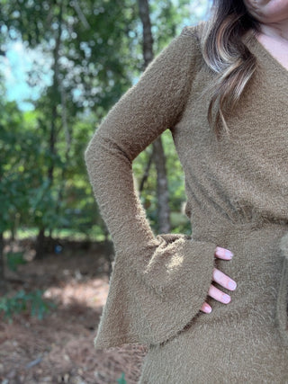 Woman wearing a green dress in a forest setting- ava wray boutique