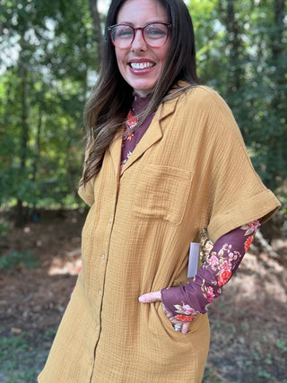 Woman wearing a mustard yellow dress with floral sleeves outdoors- ava wray boutique