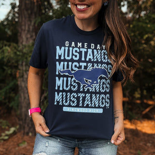 Person wearing a navy blue t-shirt with 'Mustangs' text and logo outdoors-ava wray boutique